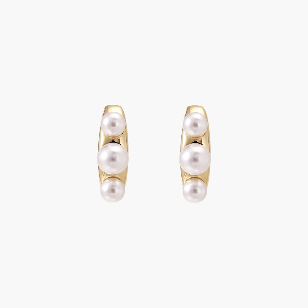 14K gold-plated curved stud earrings with three white freshwater pearls aligned vertically on cream background