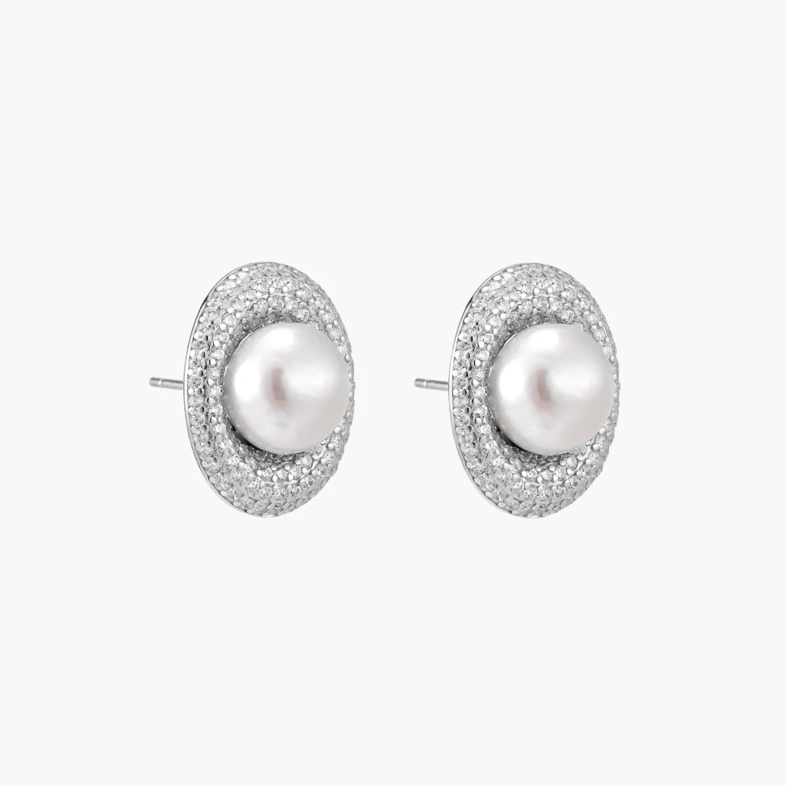 Oval rhodium-plated silver studs featuring freshwater pearls surrounded by pavé crystal halo on white background