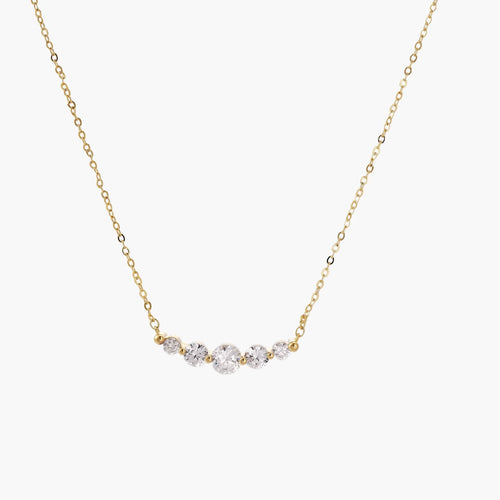 Delicate 14K gold-plated necklace with five graduated zirconia stones arranged in a curved arc on fine chain